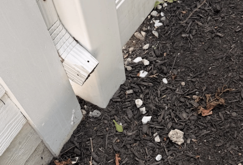 Downspout discharging roof water beside the foundation of a Newburyport MA home